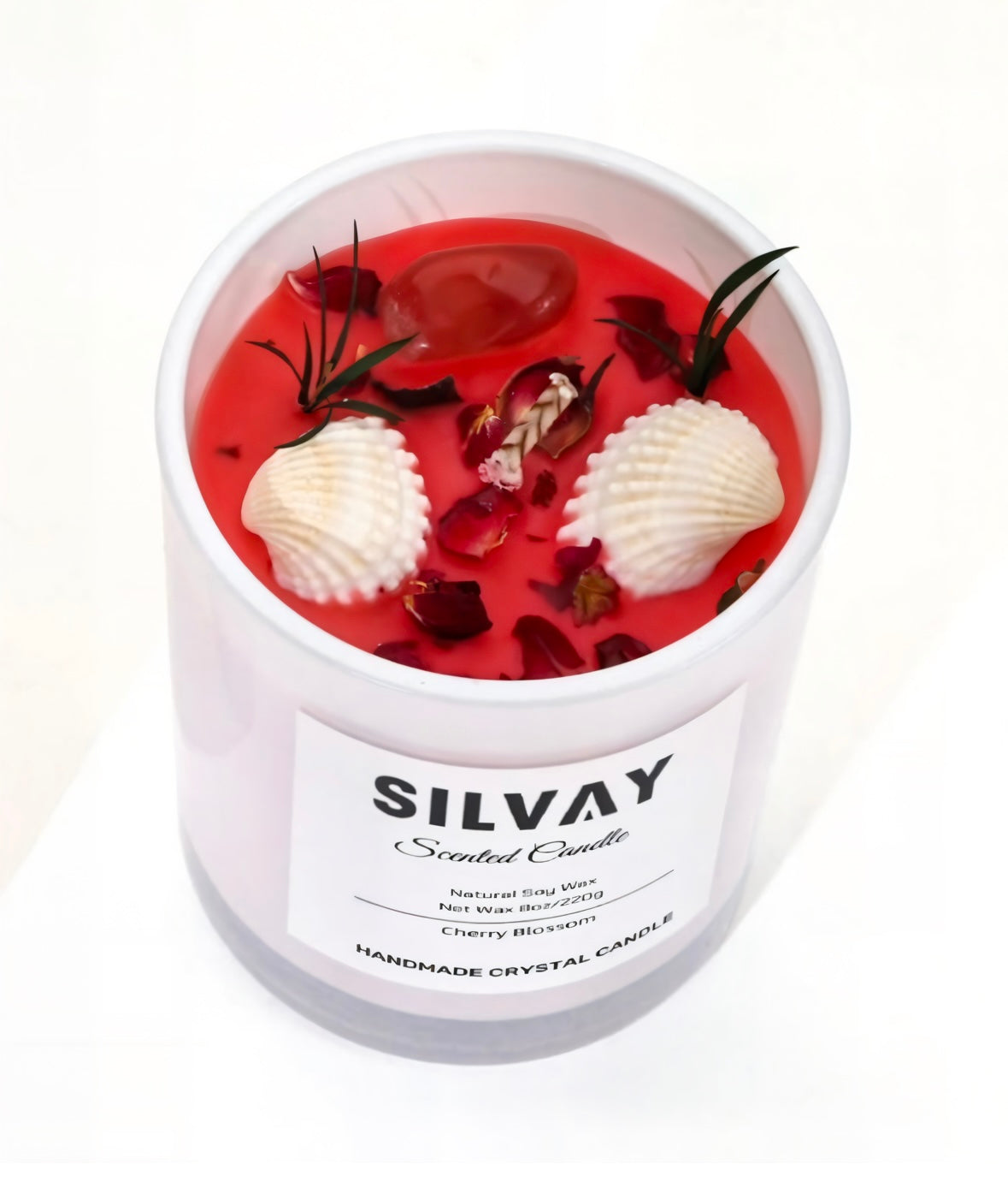 Witte pot met rode sojawaskaars, versierd met schelpen en bloemen. Geur: Cherry Blossom